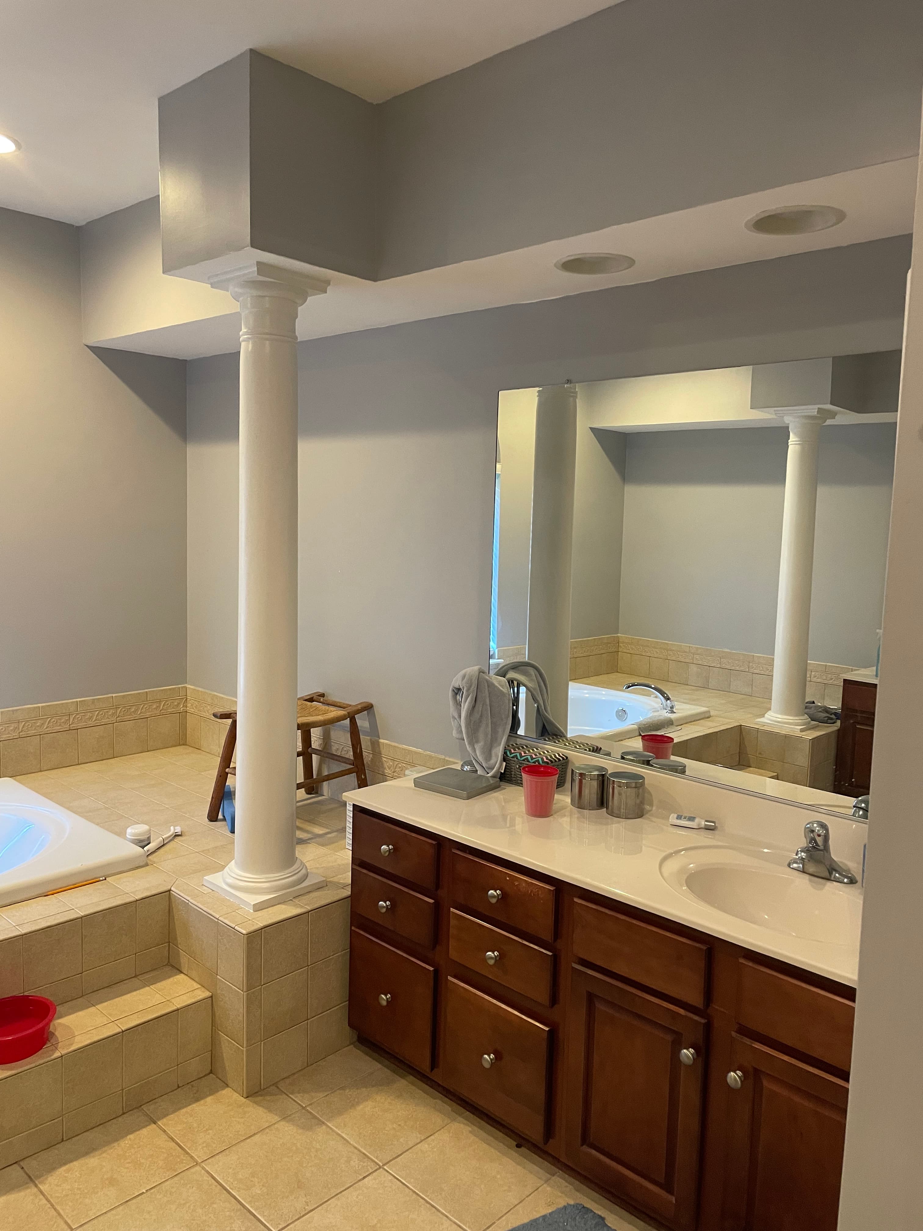 Wide view of the bathroom showing limited storage and yellow lighting before work began